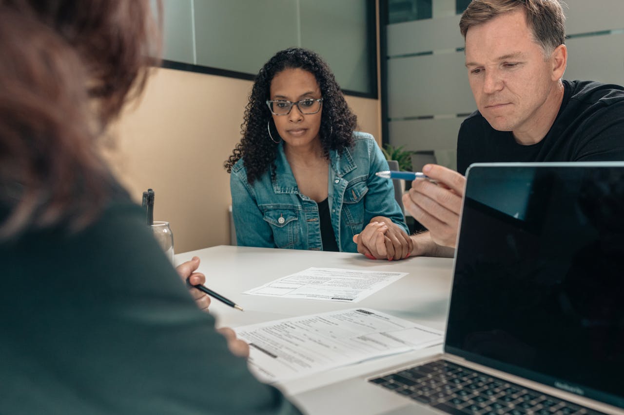 A Couple Listening to the Person Explaining the Details of the Documents on the Table